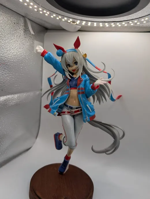 青いジャケットの少女フィギュア。木製台座で駆けるポーズ