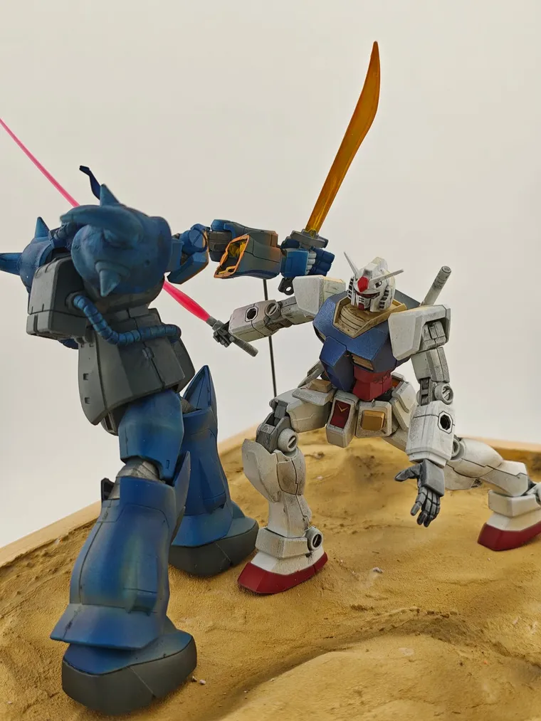 砂漠でサーベルを交えるグフとガンダムのジオラマ